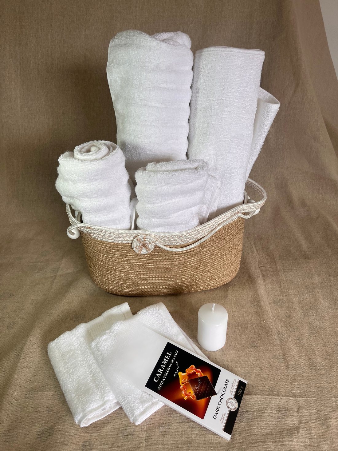 Woven rope towel holder with rolled white towels