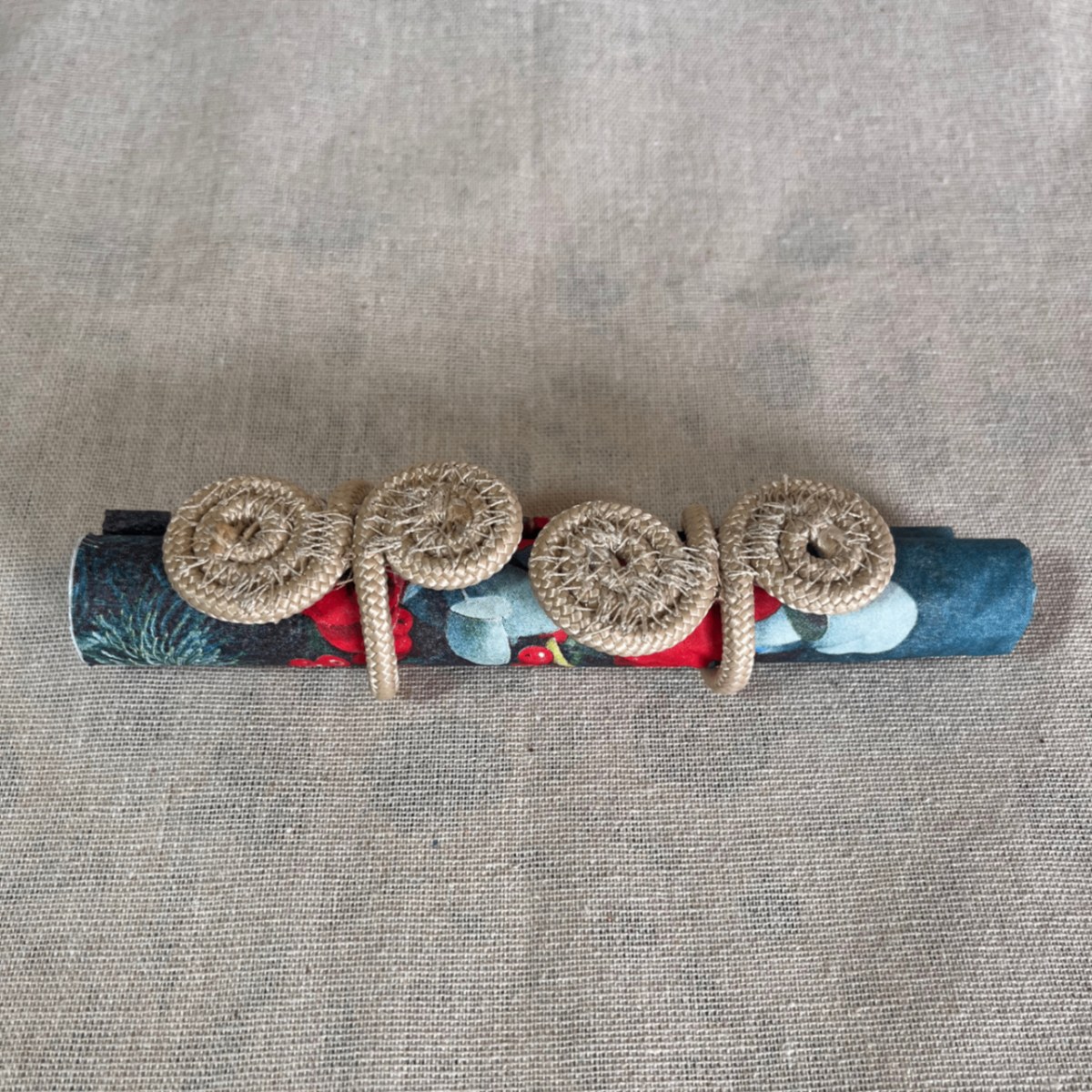 Spiral coiled rope napkin rings on a rolled patterned napkin