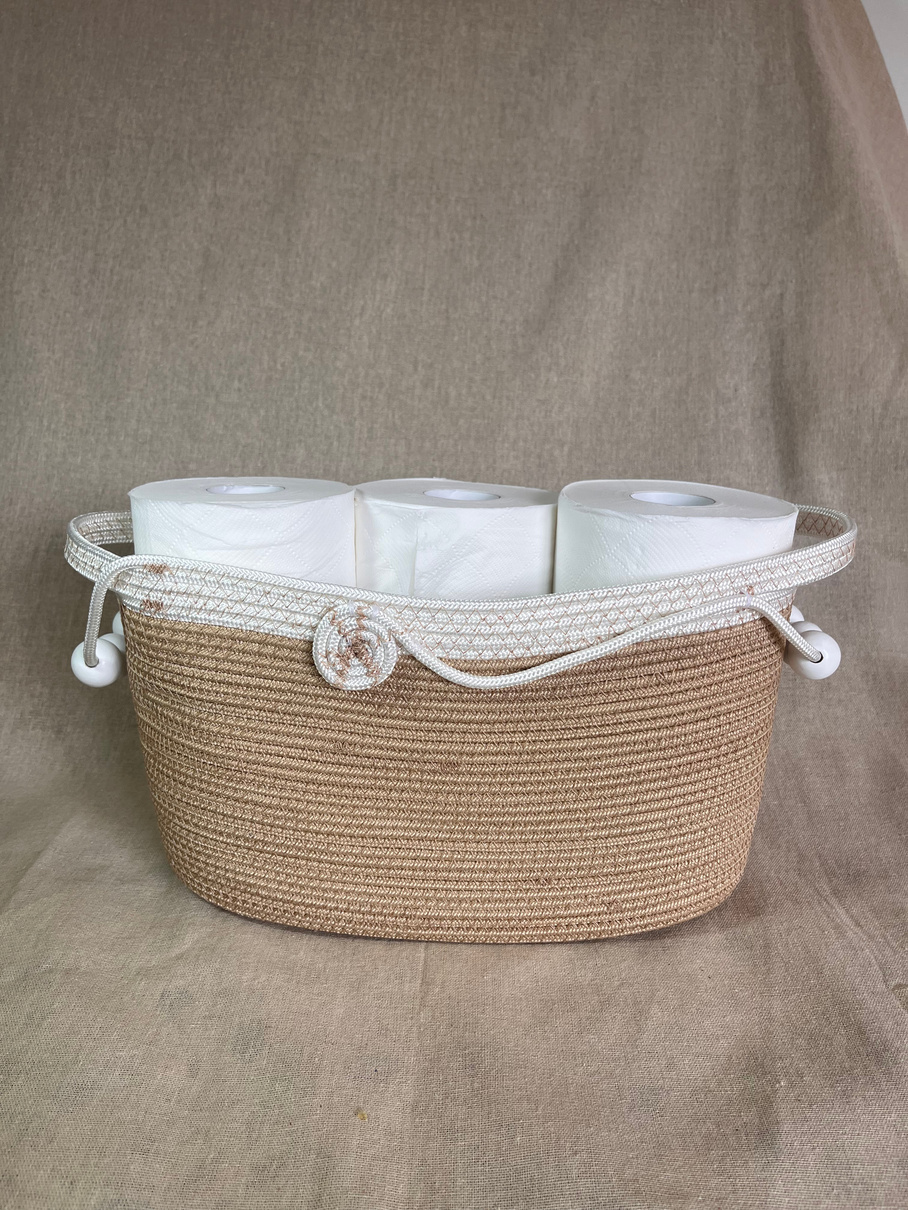 Woven rope basket holding spare toilet rolls